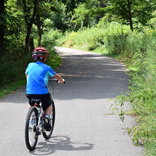 boy running bike on a trail